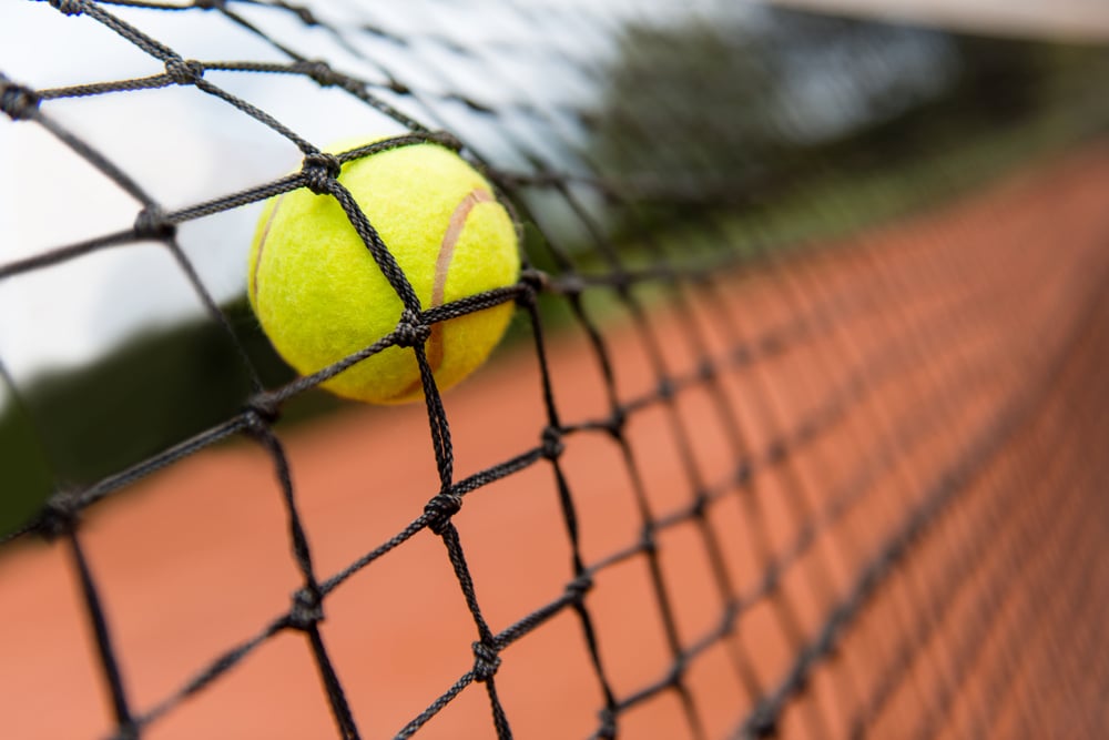 Tennis ball bouncing on the net at a clay court Tennis ball bouncing on the net at a clay court